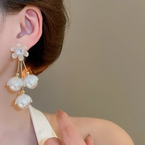 Vue détaillée de boucles d'oreilles muguet avec pompons de perles et cristaux