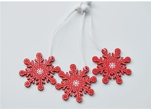 Close-up of red and white wooden snowflake ornaments with Nordic stitching patterns