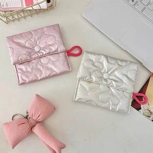 Detailed view of quilted heart pattern organizers in pink and silver with snap closure