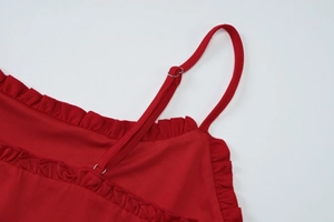 Close-up of red camisole detailing adjustable spaghetti straps and ruffled trim finish