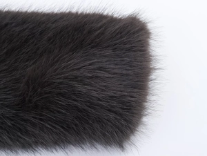 Detailed macro view of high-quality dark grey faux fur texture on a cropped coat