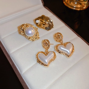 Detail of vintage flower pearl heart earrings and round pearl studs in velvet box