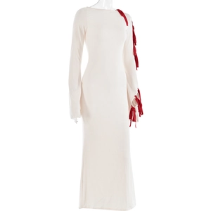 Detail view of white long sleeve dress with red bow ribbon accents on the shoulder and sleeve