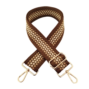 Detail showing the brown and beige geometric woven strap with golden lobster clasps