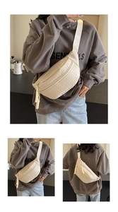 Detail view of cream woven crossbody bag showing textured fabric and adjustable strap