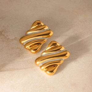 Two-tone wavy stainless steel earrings in gold and silver finish on stone background