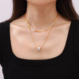 Zweilagige goldene Schlangenkette mit einem blau emaillierten Evil Eye Anhänger Charm