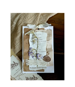 Artistic detail of vintage DIY scrapbook paper with dried flowers, lace, and wax seal stamp