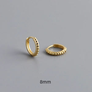 Detail view of 8mm gold S925 sterling silver hoop earrings with a dotted texture finish