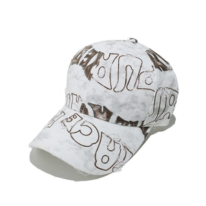 Detailed view of the distressed white baseball cap with brown graffiti-style letters