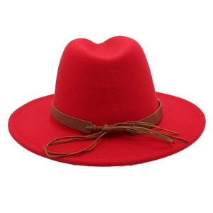 Close-up of red felt fedora hat with a brown leather belt and tassel knot detail