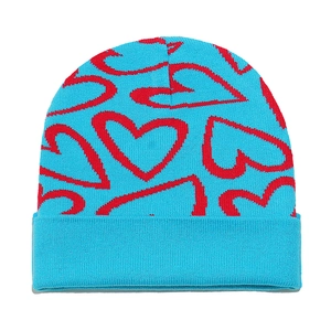 Close-up of thick ribbed cuff and red heart jacquard knit pattern on blue beanie