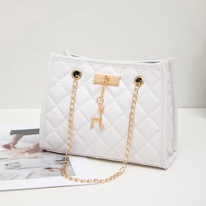 White quilted shoulder bag with gold chain strap and deer charm on a white surface