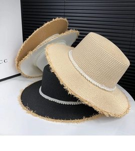 Detail of straw sun hats with pearl chains and fringe edges in black, beige and khaki