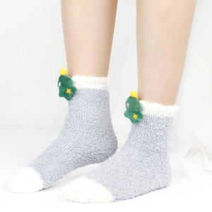 Detailaufnahme der grauen Plüschsocke aus Korallenfleece mit grünem Weihnachtsbaumdekor