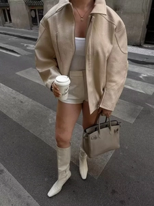 Dettaglio della giacca oversize in pelle crema con colletto a rever e texture morbida