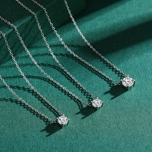 Three elegant s925 silver necklaces with sparkling round solitaire pendants on green background