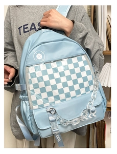 Detail of light blue nylon backpack with checkerboard clear pocket and acrylic chain