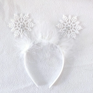 Detail of white Christmas headband with sparkling snowflakes and soft feather trim