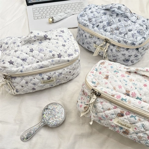 Detail view of quilted cotton makeup bags in cute floral prints with zip closure