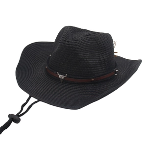 Detailed close-up of a black woven raffia cowboy hat with a metal bull head ornament