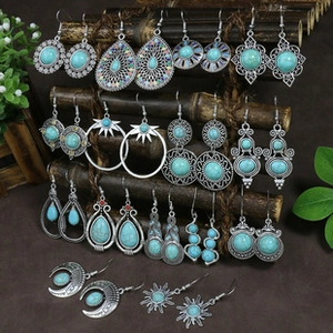 Detail of vintage bohemian silver earrings with turquoise stones on bamboo display
