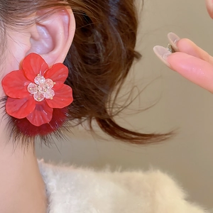 Detailed view of elegant red floral earrings with plush pom-poms and bead embellishments