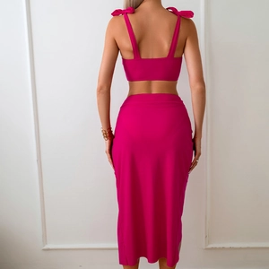 Detailed back view of a pink two-piece set with shoulder bows and high waist skirt
