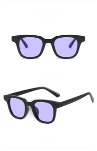 Detail view of square black frame sunglasses with transparent purple lenses and metal studs