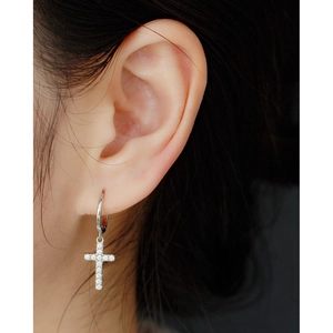 Macro view of S925 sterling silver cross earring with sparkling pave-set cubic zirconia