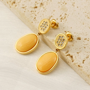 Detail of vintage gold-plated drop earrings featuring yellow faux stone and pave crystals