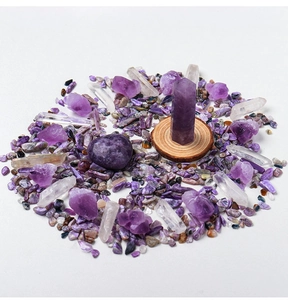 Close-up of amethyst crystal set featuring hexagonal pillars and raw gemstones on white base