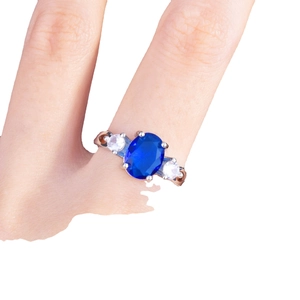 Elegant silver three-stone ring featuring a large oval blue sapphire and side stones