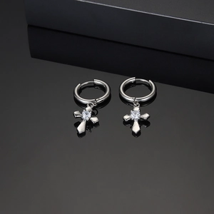 Polished silver stainless steel cross earrings with zircon on black reflective background