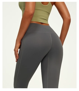 Detail of high waisted yoga pants in dark grey featuring wide compression waistband and seams