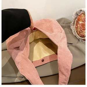 Detail shot of pink corduroy tote bag showing beige lining and magnetic closure