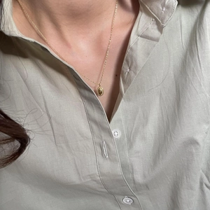 Elegant 925 sterling silver gold necklace featuring a textured oval pendant on model