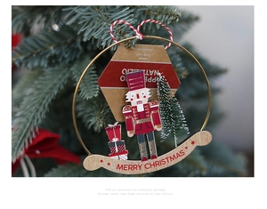 Detail of wooden nutcracker in gold metal ring hanging on Christmas tree branch