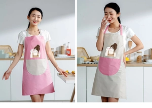 Close-up of waterproof aprons in pink and beige with cute cartoon patterns in a kitchen