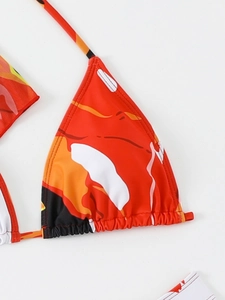 Dettaglio del top bikini con stampa astratta rossa, coppe a triangolo e arricciature