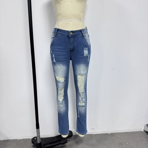 Détails d'un jean en denim vieilli avec trous symétriques aux genoux et délavage usé