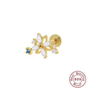 Macro view of 925 sterling silver gold stud with blue and clear gemstones flower cluster