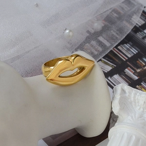 Exaggerated golden lip-shaped ring in 18K gold plated titanium on mannequin hand