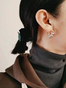 Detailed view of S925 sterling silver twisted hoop earrings worn by a model