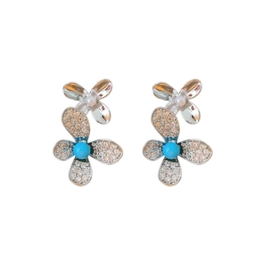 Silver flower earrings with pearls, blue gemstones, and rhinestones on white background