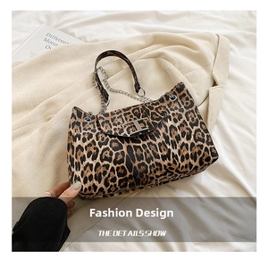 Detail shot of leopard print tote bag featuring metallic T-buckle and chain strap