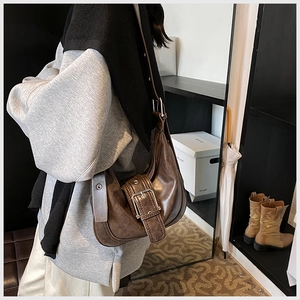 Vintage braune Halbmond-Tasche mit dekorativer Gürtelschnalle und Lederriemen im Detail