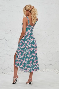 Detail of blue floral sleeveless midi dress with side slit and backless design on a model
