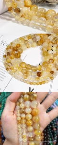 Macro view of natural yellow quartz crystal beads with internal needle inclusions