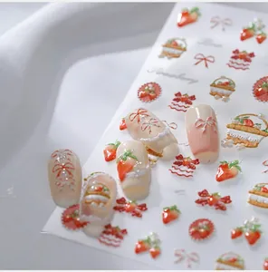 Detail of 3D embossed strawberry nail art stickers with red bows and lace patterns